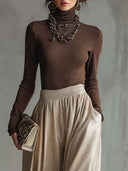 Conjunto elegante y a la moda de top marrón retro de cuello alto tejido y falda plateada brillante