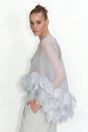 Top tipo capa em organza transparente adornado com pétalas